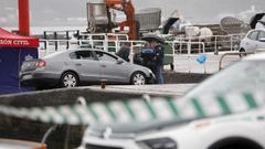 Miembros de la polica local, la polica judicial y la Guardia Civil al lado del coche que se cay al mar y en el que viajaba la mujer fallecida