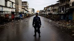 Un polic�a patrulla en una calle vac�a en Freetown, Sierra Leona