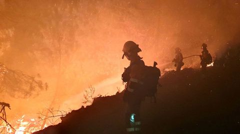 Integrantes de la brigada de bomberos forestales con base en la localidad leonesa de Tabuyo, esta noche en el incendio de Pacios da Serra