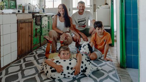 Aurora y Miqueas junto a sus hijos Marcos y Lucas y su perro en su nueva casa en una aldea gallega.
