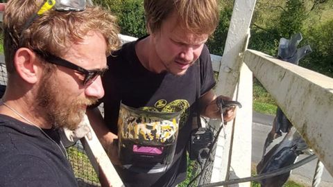 Dennis Schep y el herrero ruso Pavel Yakushev, asentados enBravos (Ourol), instalando en una gran farola de Notre-Dame-Des-Landes, en Francia, una escultura con pjaros de papel forjados en hierro