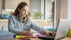 Una adolescente, consultando el ordenador mientras hace los deberes, en una imagen de archivo.