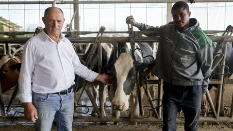 Manolo Barrio, propietario de la granja Casa Castro (Sobrado dos Monxes, A Corua) junto a Allasane Bah, inmigrante de Mali que contrat.