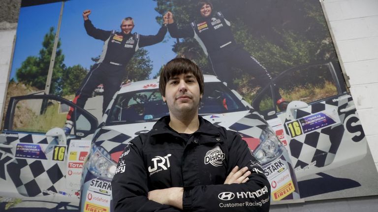 Daniel Berdom&aacute;s, en su taller ante una fotograf&iacute;a de su propio equipo tras ganar un rali.