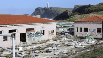 Estado de la antigua planta de acuicultura, con el faro de Punta Frouxeira al fondo