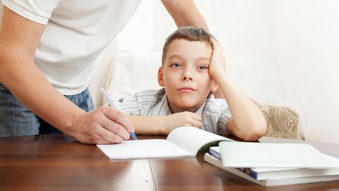 Ni�o haciendo deberes y padre ayud�ndole