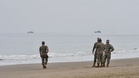 Integrantes de la Armada de Ecuador vigilan la playa El Murcilago ante la alerta de tsunami.
