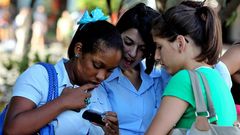 Unas j�venes usan sus m�viles en Cuba