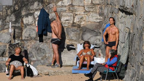 Un grupo de personas toman el sol en la playa de San Lorenzo de Gijón