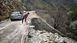 Una vecina se asoma al barranco sobre el que se apoya la carretera que comunica todas estas aldeas en uno de los tramos deteriorados