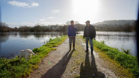 Pepe Ba&ntilde;os y Ricardo Loureiro, vecinos de Godos, Caldas, mostrando el desborde del Umia