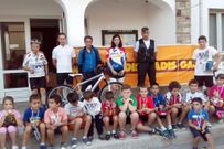 Los ciclistas galardonados posan ante el Concello de Rois 