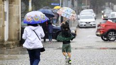 Un nio trata de taparse de la lluvia en Monforte