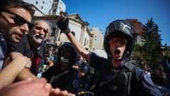 Un agente antidisturbios habla con Eduardo Belliboni, de Polo Obrero, en las manifestaciones en Buenos Aires contra los recortes anunciados por el Gobierno argentino.