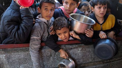 Unos ni�os hacen cola para adquirir ayuda humanitaria en Rafah.