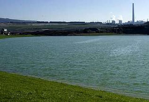Un murall�n de tierra separa las aguas del lago del centro de As Pontes, desde donde a�n no es visible