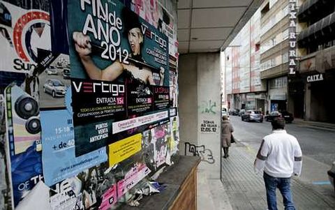 Los carteles promocionando fiestas de Nochevieja inundan muros y farolas de la ciudad.