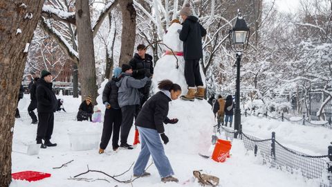 Un grupo de ni�os hacen un mu�eco de nieve en Nueva York