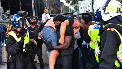 Un manifestante traslada a otro que result herido en las protestas en Londres