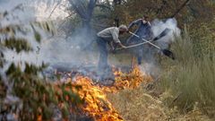 Vecinos de Pentes colaboran para que el fuego no cruce el camino que les separa de sus casas.