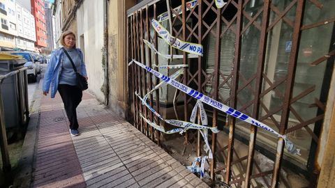 Una mujer pasa delante del n�mero 29 de la avenida de Peruleiro, precintado por la Polic�a este jueves. MARCOS M�GUEZ