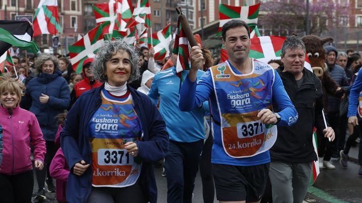El lendakari Imanol Pradales y la vicelendakari, durante la Korrika 2026, en la que se exhibieron pancartas de apoyo a los presos de ETA.