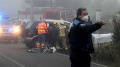 Un polic�a local dirige el tr�fico mientras bomberos y sanitarios sacan del coche a uno de los heridos