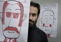 Pintor, con dos de los dibujos que hizo para el cartel del entroido coru��s. 