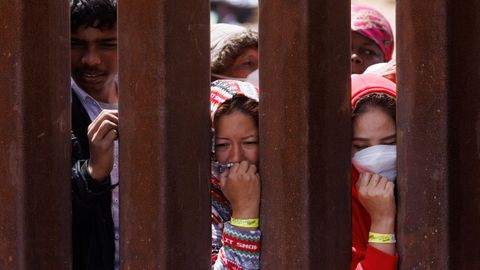 Migrantes en la valla de San Diego.