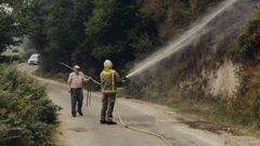 Un bombero ayuda a un vecino a extinguir un fuego en Trives