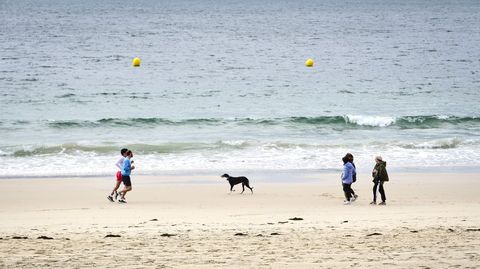 Pese a los intermitentes aguaceros, haba algunas personas paseando y corriendo por la playa de Silgar. 