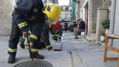 Bomberos del parque de Chantada revisando una alcantarilla en el casco urbano, en una imagen de archivo
