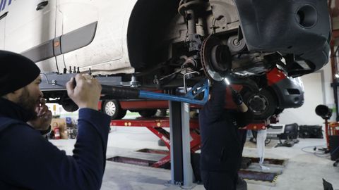 Empleados de un taller mecnico de Ourense reparando un vehculo