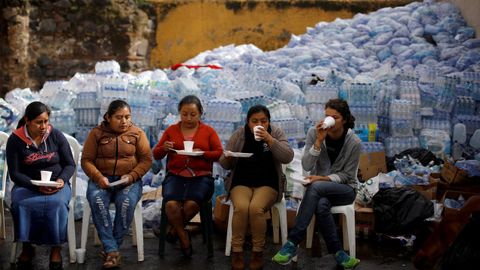 Un grupo de mujeres toman caf� en el �rea afectada por la erupci�n del volc�n de Fuego, en Alotenango (Guatemala)
