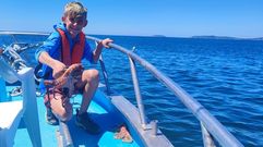 Uno de los turistas norteamericanos con un pulpo en la actividad de pescaturismo del Playa de Sanxenxo