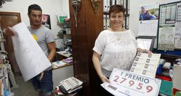 Nieves Moreda, titular de la administraci�n n�mero 1, y un familiar colocando ayer los carteles del primer premio. 