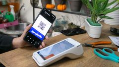 Una usuaria del programa MercaNaVila utiliza uno el bono de descuento en un comercio.