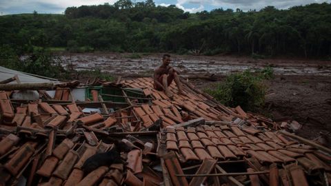 Un superviviente sobre los restos de su casa, completamente destrozada