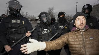 Cuatro agentes del ICE junto a un manifestante en la ciudad de Mine�polis.