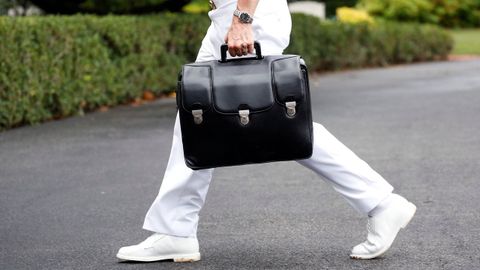 Un militar transporta el malet�n con los c�digos de las armas nucleares al regreso de Donald Trump a la Casa Blanca.