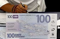 El eurodiputado Ra�l Romeva, de Los Verdes, muestra un billete contra las ayudas.