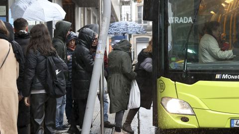 Una de las paradas de bus de la plaza de Galicia, sin marquesina y con viajeros bloqueando por completo la acera