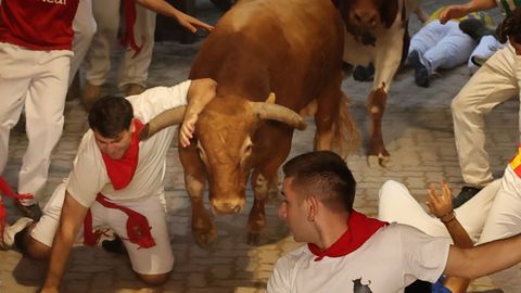  Un mozo es alcanzado por uno de los toros de la ganader�a gaditana de La Palmosilla a su paso por el callej�n 