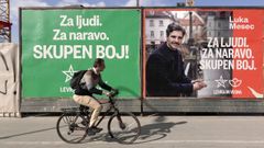 Un hombre pasa en bicicleta junto a carteles preelectorales en el centro de Liubliana, Eslovenia.