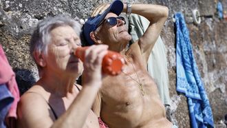 CALOR.Dos personas se refrescan tomando agua este mediod�a en A Coru�a, donde la ciudad ha marcado los 35 grados