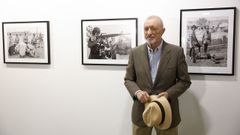 P�rez-Reverte, posando con sus im�genes en la exposici�n �Fotograf�as de guerra (1974-1985)�.