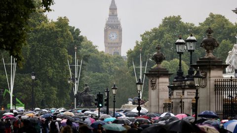 La lluvia no impidi� a muchas personas acudir a rendir homenaje a la reina delante del palacio real.