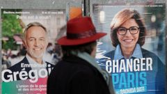 Un hombre pasa ante los carteles electorales de los aspirantes a alcaldes de Par�s Enmanuel Gregoire y Rachida Dati.