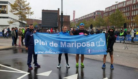 Los cuatro burelenses posan con una pancarta de la Asociaci�n DEBRA tras completar la prueba.