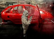 Dos operarios pintan un modelo de Citroen en la factor�a de PSA en Bala�dos.